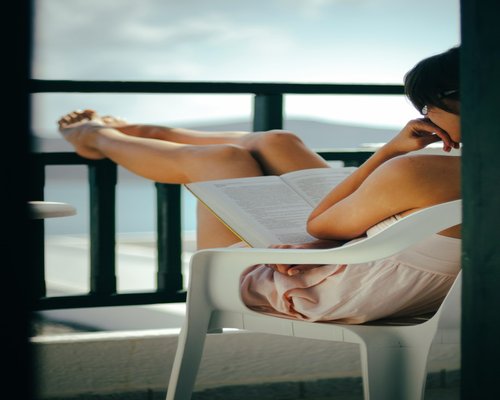Person resting comfortably in a chair reading a book