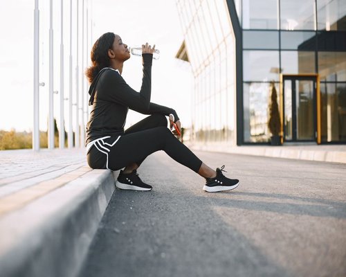 Person resting with a glass of water on a warm day